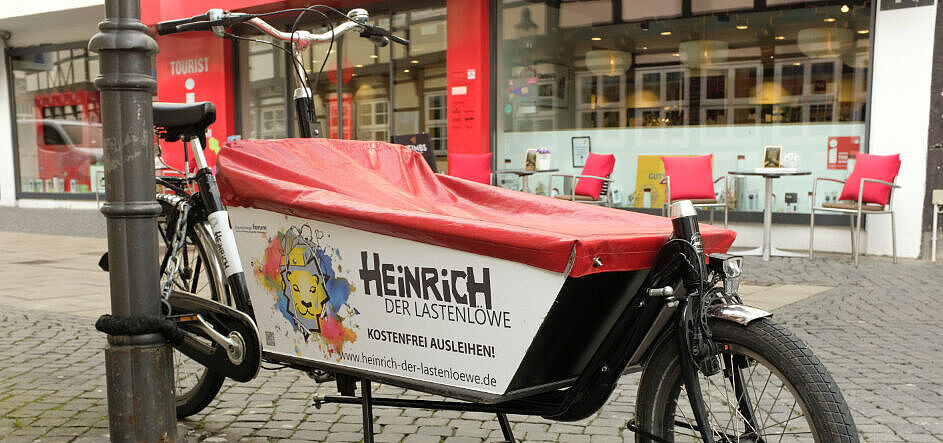 Das Bild zeigt ein Lastenfahrrad mit dem Aufdruck: Heinrich der Lastenlöwe - kostenfrei ausleihen